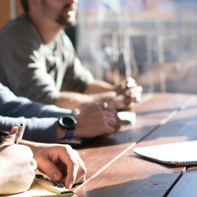 Personnes discutant et prenant des notes autour d'une table