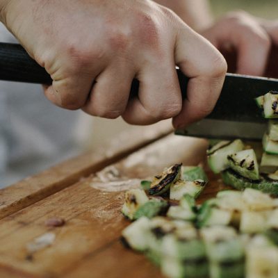 Personne coupant des légumes sur une planche à découper